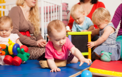 Grupo de bebés en la guardería con sus cuidadoras