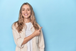 Mujer joven sonríe y señala